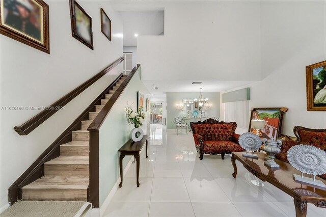 interior space featuring a high ceiling, a notable chandelier, and light tile patterned floors