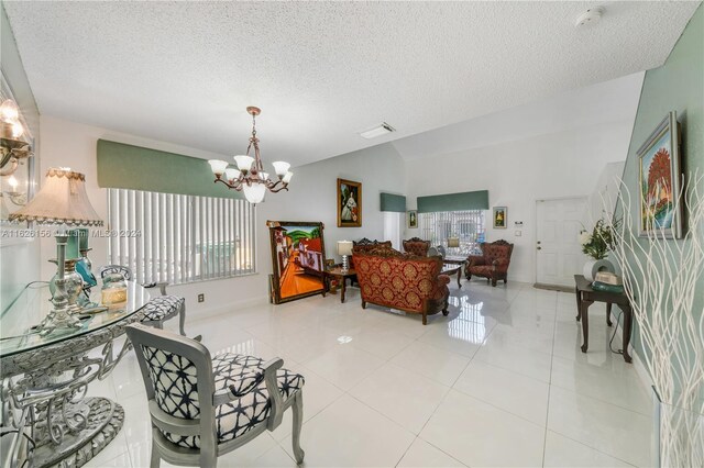 dining space with lofted ceiling, a notable chandelier, light tile patterned floors, and a textured ceiling