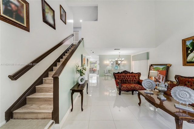 stairs featuring tile patterned flooring, baseboards, a high ceiling, and a notable chandelier