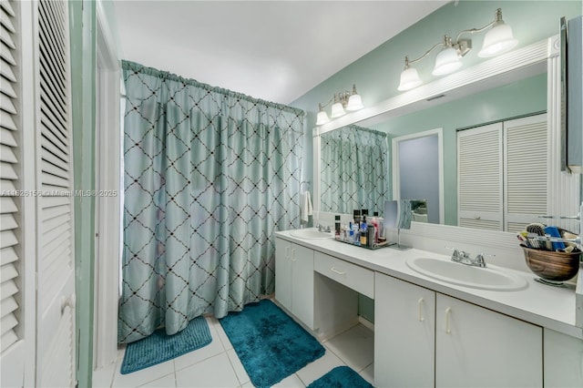 full bath featuring double vanity, a sink, tile patterned flooring, and a closet