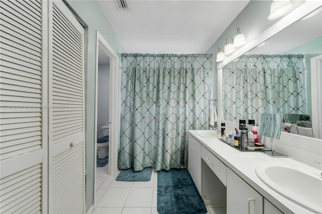 bathroom with toilet, tile patterned floors, visible vents, and a sink