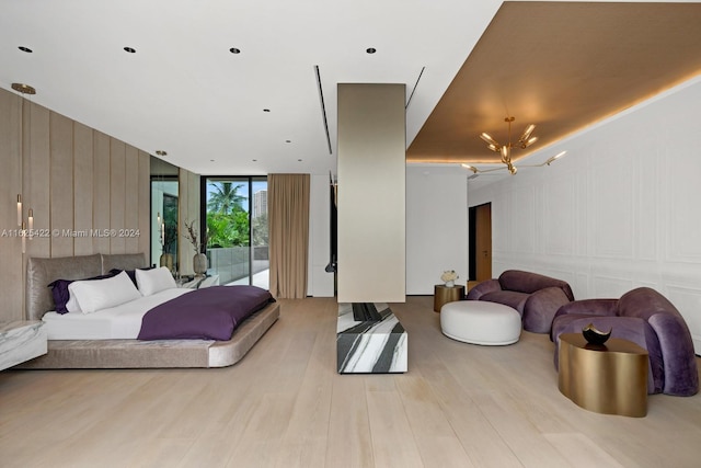 bedroom with a chandelier, access to outside, light hardwood / wood-style flooring, and floor to ceiling windows