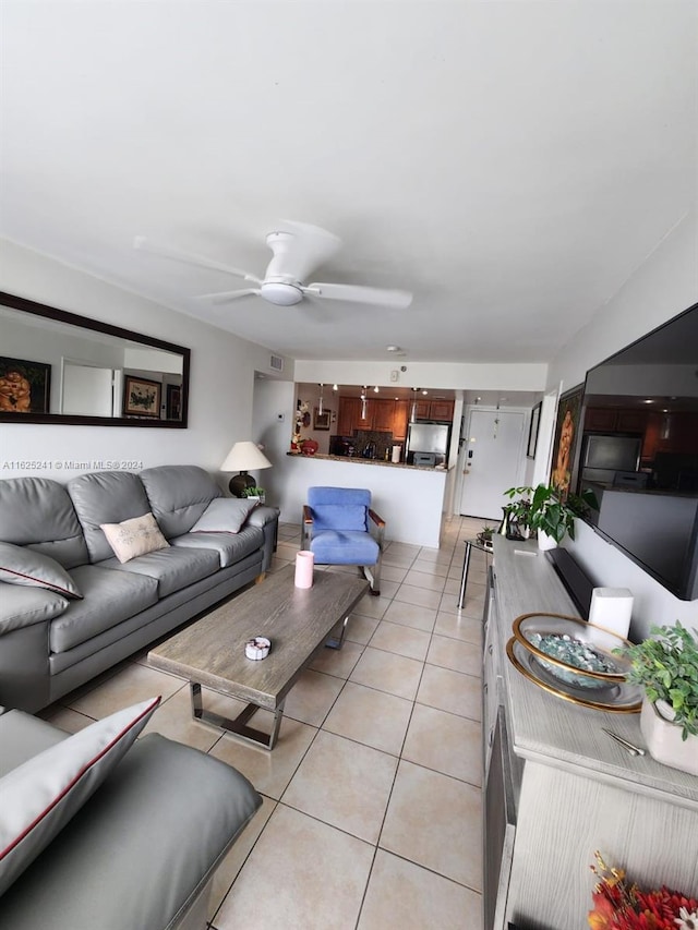 living room with a ceiling fan and light tile patterned flooring