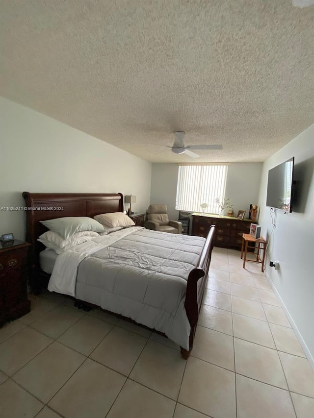bedroom with a ceiling fan, a textured ceiling, and light tile patterned floors