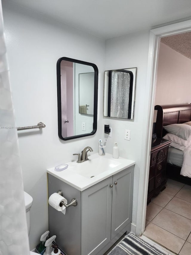 bathroom featuring tile patterned flooring, vanity, connected bathroom, and toilet