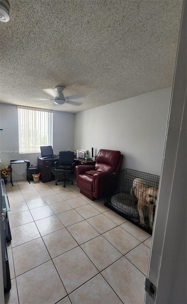 living room featuring ceiling fan, a textured ceiling, and light tile patterned floors