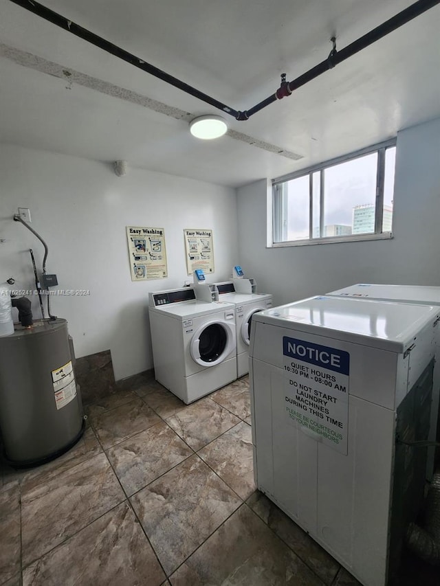 community laundry room with water heater and separate washer and dryer