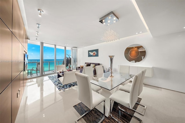 dining room with a water view and a wall of windows