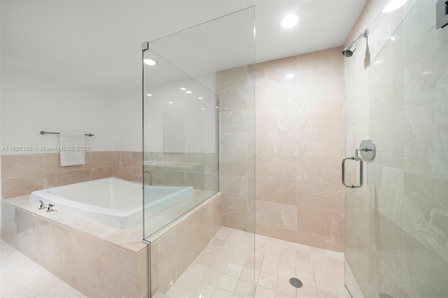 bathroom with tile patterned flooring and separate shower and tub