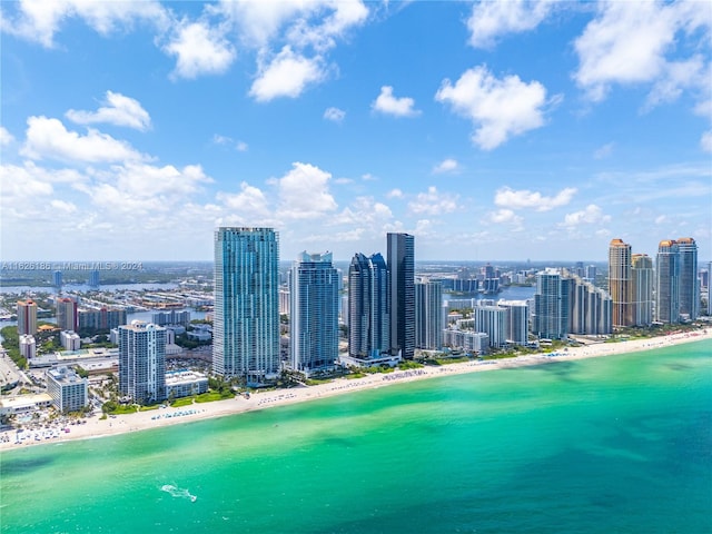 birds eye view of property with a water view and a beach view