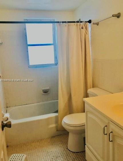 full bathroom with vanity, shower / tub combo with curtain, toilet, and tile patterned flooring