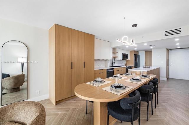 dining room featuring light parquet floors, sink, and an inviting chandelier