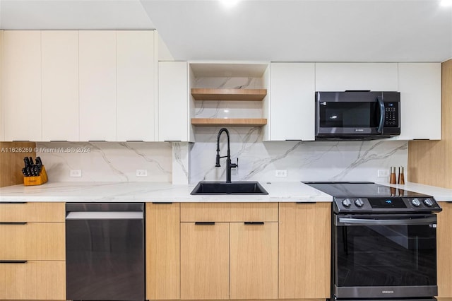 kitchen featuring tasteful backsplash, light brown cabinets, sink, light stone counters, and appliances with stainless steel finishes