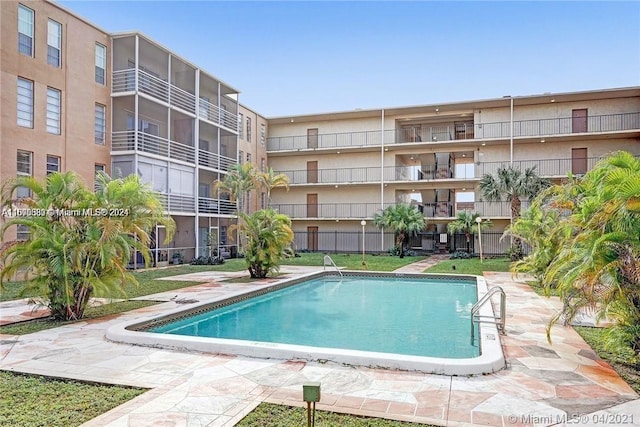 view of swimming pool featuring a yard