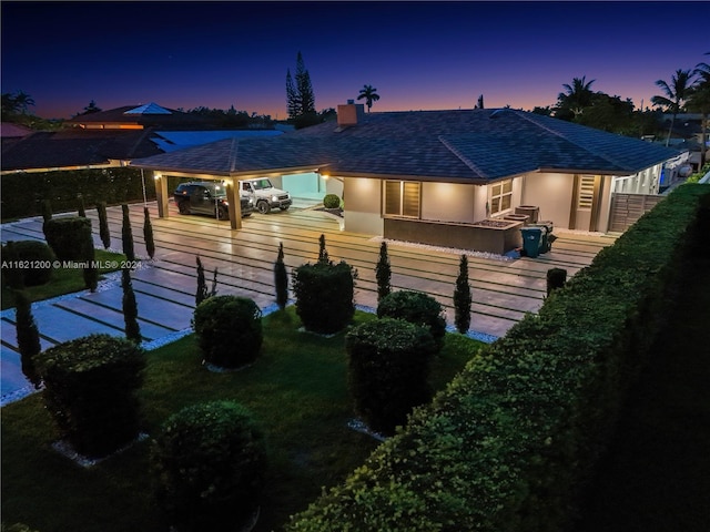 back house at dusk with a deck