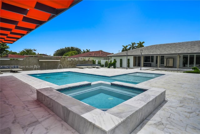 view of pool featuring a patio and an in ground hot tub