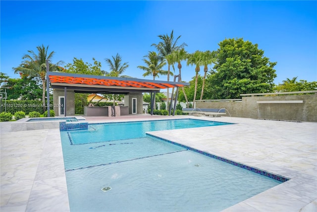 view of swimming pool with pool water feature and a patio