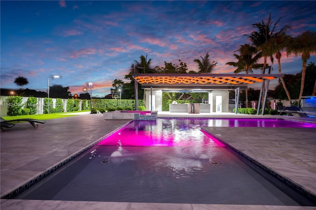 pool at dusk featuring a patio area and pool water feature