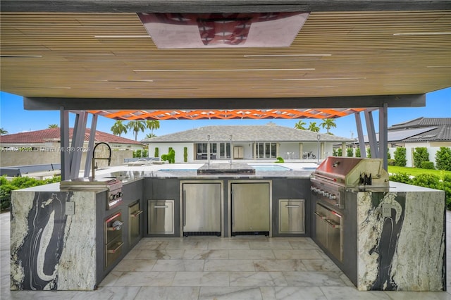 view of patio featuring area for grilling and sink