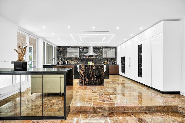 kitchen featuring ventilation hood, a center island, and decorative backsplash