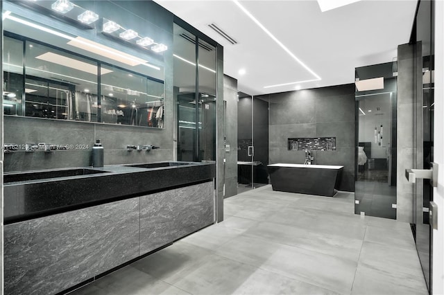 bathroom with tile walls, separate shower and tub, and vanity