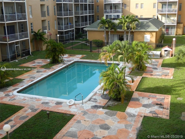 view of swimming pool featuring a yard