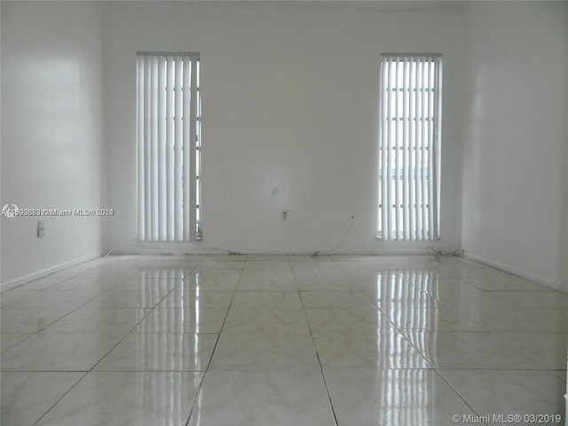 unfurnished room with a wealth of natural light and light tile patterned floors