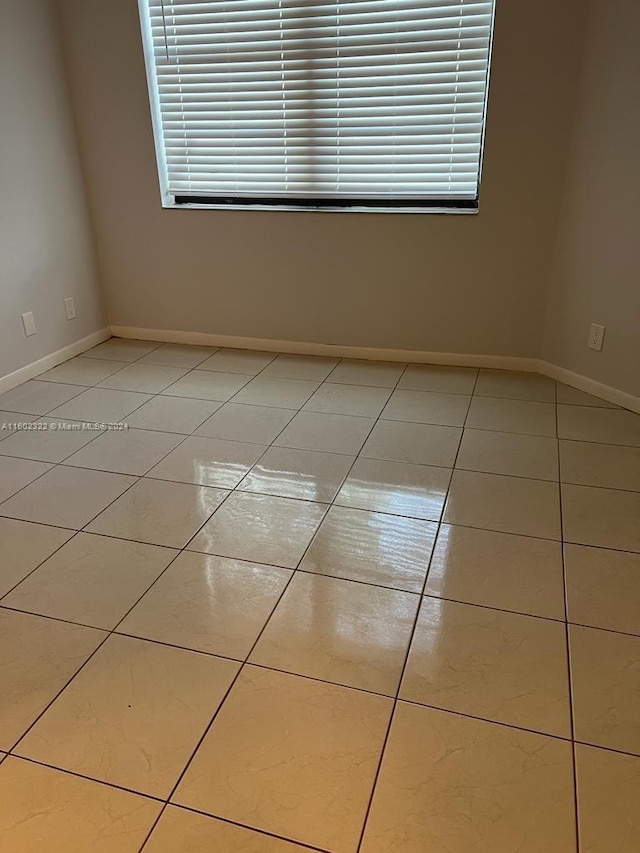 tiled empty room with a wealth of natural light