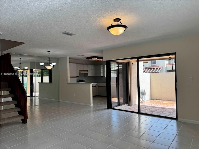 interior space featuring stairway, light tile patterned flooring, plenty of natural light, and visible vents