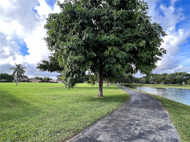 view of property's community with a water view and a yard