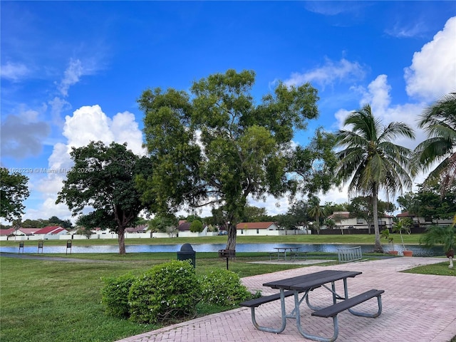 surrounding community featuring a lawn and a water view