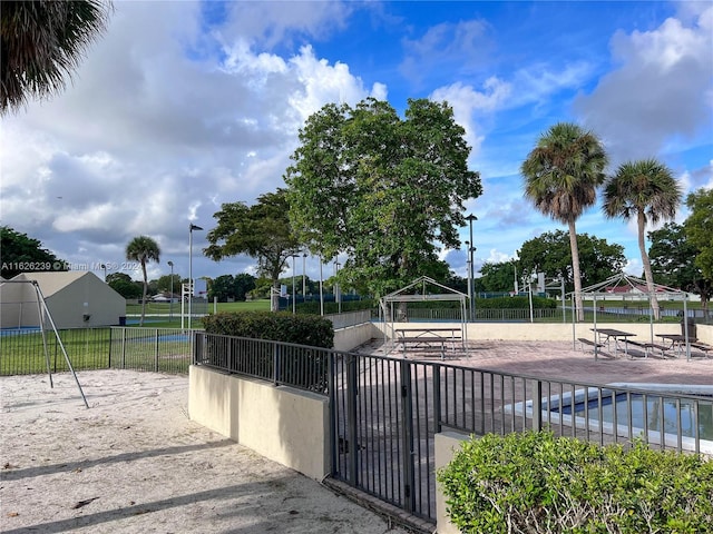 view of property's community featuring playground community and fence