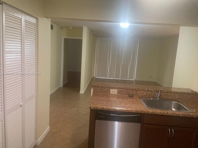 kitchen with sink, light tile patterned floors, and stainless steel dishwasher