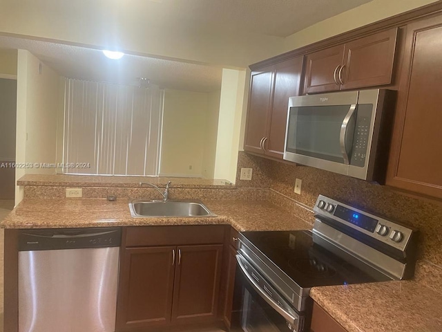 kitchen featuring stainless steel appliances, tasteful backsplash, and sink