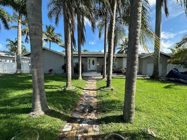 single story home with a garage and a front lawn