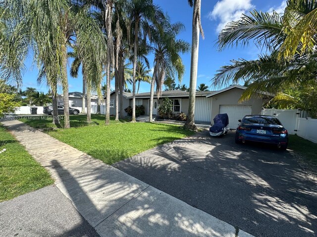 view of front of home with a garage and a front lawn