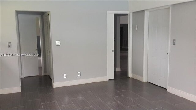 unfurnished bedroom featuring dark hardwood / wood-style flooring and a closet