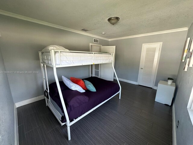 unfurnished bedroom featuring crown molding and a textured ceiling