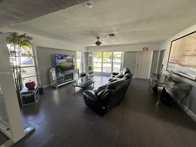 living room with a textured ceiling and ceiling fan