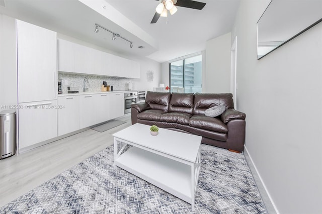 living room with sink, track lighting, ceiling fan, and light wood-type flooring