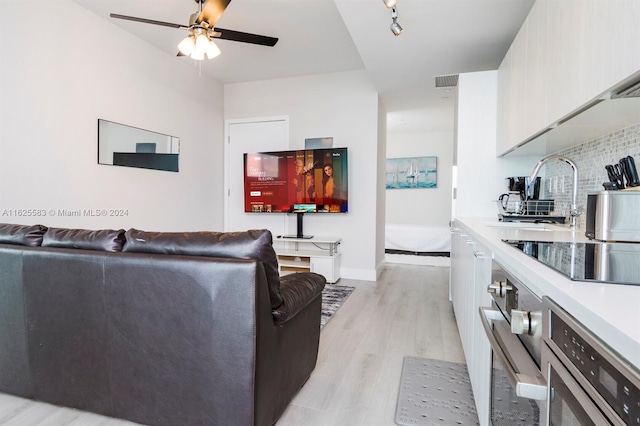 living room featuring ceiling fan and light wood-type flooring