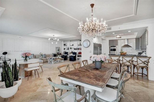 tiled dining area with a notable chandelier, a raised ceiling, ornamental molding, and built in features