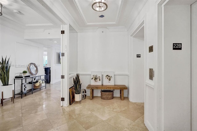 hallway with light tile patterned floors, a raised ceiling, and crown molding