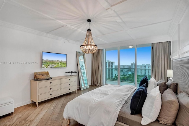 bedroom featuring hardwood / wood-style floors, an inviting chandelier, baseboards, and ornamental molding