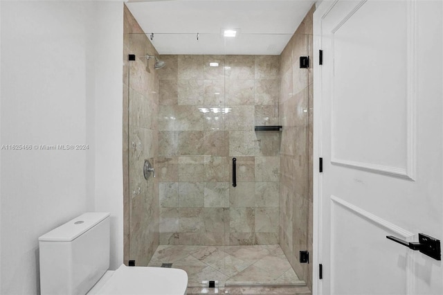 bathroom with toilet and a shower with shower door