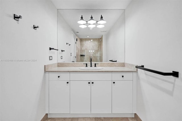 bathroom with tiled shower, tile patterned floors, and vanity