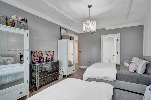 bedroom with an inviting chandelier, crown molding, hardwood / wood-style floors, and a tray ceiling