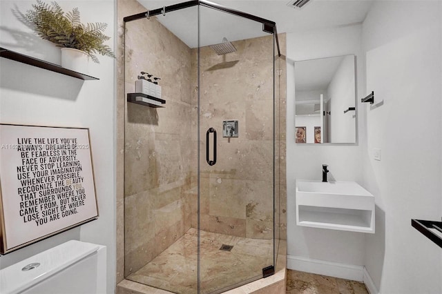 full bathroom with a shower stall, toilet, and baseboards