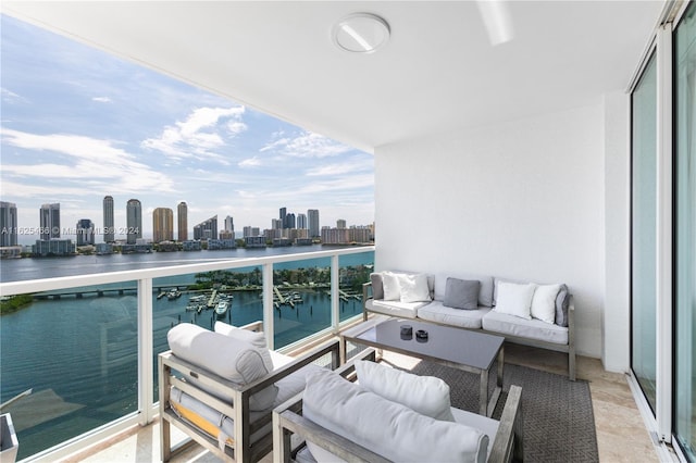 balcony featuring an outdoor living space and a water view