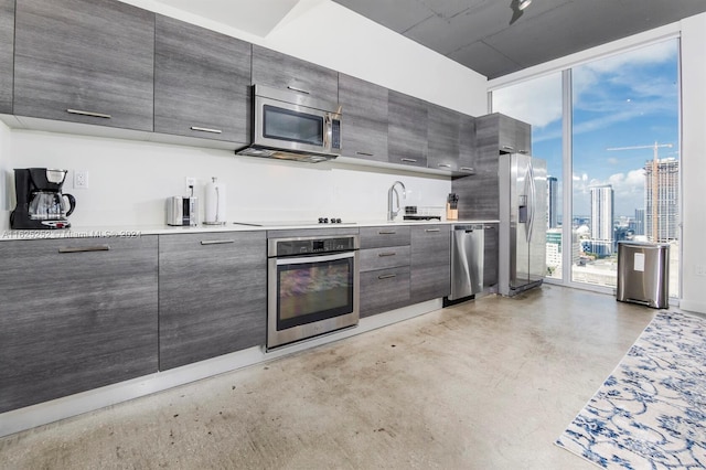 kitchen with stainless steel appliances, floor to ceiling windows, and sink